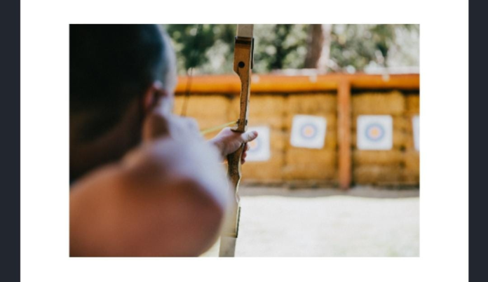 What colour is the centre scoring zone of the target in this sport