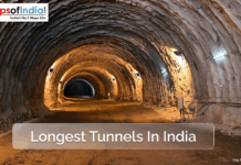 Longest Tunnels in India A view inside a large, illuminated tunnel in India, showcasing rough rock walls and ceiling with construction lights, representing one of the country's longest tunnels.