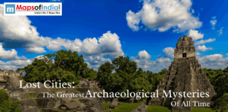 Lost Cities: The Greatest Archaeological Mysteries of All Time Ancient Mayan ruins surrounded by lush green forest under a bright blue sky with white clouds, representing lost cities and great archaeological mysteries.