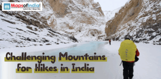 Challenging Mountains for Hikes in India Trekkers hiking on a frozen river surrounded by snow-covered mountains in India – representing challenging mountain hikes