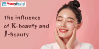 The Influence of K-Beauty and J-Beauty A woman with glowing skin applies skincare cream to her cheeks while smiling, representing the concept of K-beauty and J-beauty.
