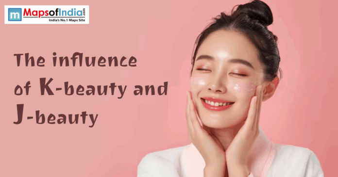 A woman with glowing skin applies skincare cream to her cheeks while smiling, representing the concept of K-beauty and J-beauty.