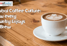 Global Coffee Culture: How Every Country Enjoys Its Brew A cup of coffee placed on a brown table with a logo of maps of india on the left corner of the image