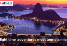 Night Time Adventures Most Tourists Miss A vibrant coastal city at dusk with glowing lights, mountains, and a calm bay, illustrating night-time adventures most tourists miss.