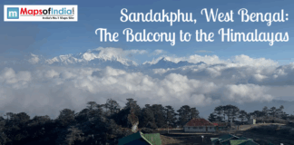 Sandakphu, West Bengal: The Balcony to the Himalayas Panoramic view of Sandakphu in West Bengal, showing snow-covered Himalayan peaks rising above clouds, with forested hills and rooftops in the foreground, known as the Balcony to the Himalayas.