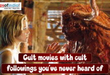 Cult Movies with Cult Followings You’ve Never Heard Of A woman stands face-to-face with a large, monstrous creature inside a dim, cluttered room. She reaches her hand toward the creature as they appear to confront or communicate with each other.