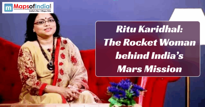 ritu karidhal Indian aerospace scientist Ritu Karidhal sitting on a red sofa in a beige and red saree, with a text banner that reads “Ritu Karidhal: The Rocket Woman behind India’s Mars Mission” on a purple background.