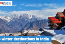 Top winter destinations in India A snow-covered mountain resort in Auli, Uttarakhand, India, featuring a multi-story wooden building with red roofs overlooking the majestic Himalayan peaks under a bright blue sky.