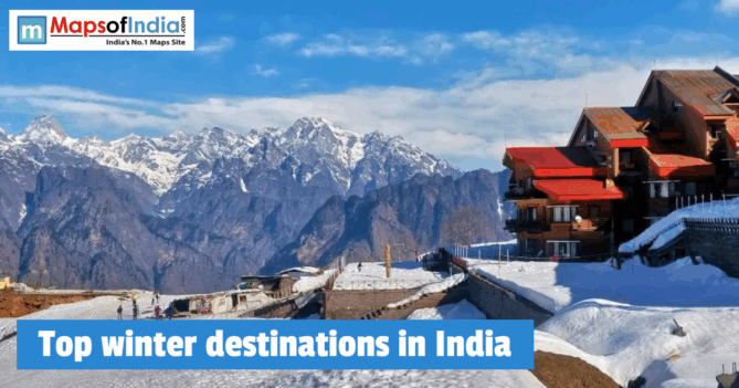 A snow-covered mountain resort in Auli, Uttarakhand, India, featuring a multi-story wooden building with red roofs overlooking the majestic Himalayan peaks under a bright blue sky.
