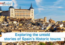 Exploring the Untold Stories of Spain’s Historic Towns Panoramic view of the historic city of Toledo, Spain, featuring the Alcázar fortress on a hill overlooking a dense cluster of traditional buildings under a blue sky.