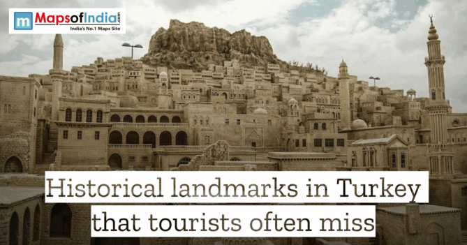 An old stone city built into a hillside in Turkey, featuring traditional Artuqid architecture with domed buildings and tall minarets under a cloudy sky. The image includes a "Maps of India" logo and text overlay that reads, "Historical landmarks in Turkey that tourists often miss."