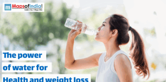 The Power Of Water For Health And Weight Loss An Asian woman with her hair in a ponytail is outdoors, drinking water from a clear plastic bottle. The text on the image reads, "The power of water for Health and weight loss," with a "Maps of India" logo in the top left corner.
