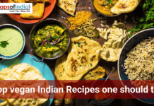 Top Vegan Indian Recipes One Should Try Overhead view of a vegan Indian meal spread with rice, naan, curry, chutney, papad, spices, and herbs, featuring the text “Top vegan Indian recipes one should try.”