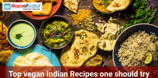 Top Vegan Indian Recipes One Should Try Overhead view of a vegan Indian meal spread with rice, naan, curry, chutney, papad, spices, and herbs, featuring the text “Top vegan Indian recipes one should try.”