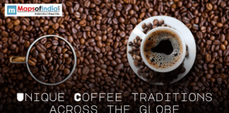 Unique Coffee Traditions Across the Globe Top-down view of a cup of freshly brewed coffee and a mug filled with roasted coffee beans on a background of scattered beans, with text reading “Unique Coffee Traditions Across the Globe,” branded by MapsofIndia.com.
