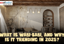 What Is Wabi-Sabi And Why Is It Trending In 2025 A wabi-sabi style living room featuring textured stone walls, wooden ceiling beams, and minimalist furniture, illustrating the 2025 interior design trend.