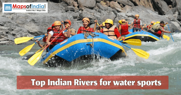 People enjoying river rafting on an Indian river, wearing safety helmets and life jackets during a water sports adventure.