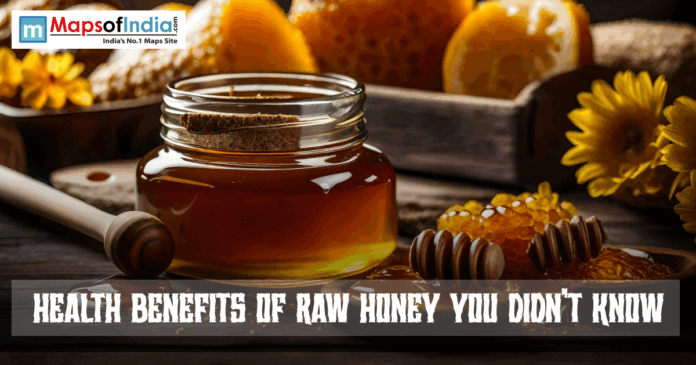 Jar of raw honey with a wooden dipper and honeycomb on a rustic table, with sunflowers in the background and the text “Health Benefits of Raw Honey You Didn’t Know” displayed.