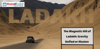 The Magnetic Hill of Ladakh: Gravity Defied or Illusion Car driving on a desert highway in Ladakh near Magnetic Hill with mountains in the background and a sign reading “The Magnetic Hill of Ladakh: Gravity Defied or Illusion.”