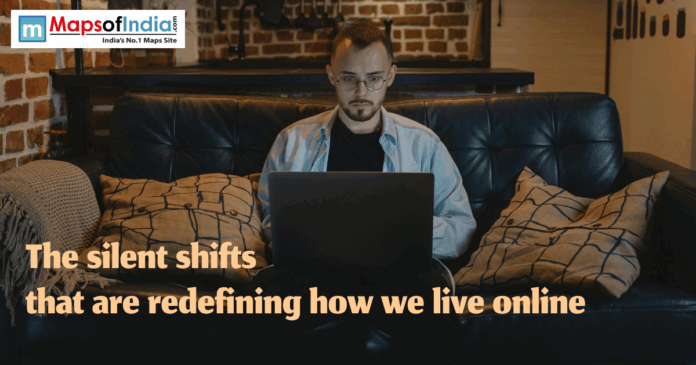 A young man using a laptop while sitting on a couch, symbolizing the silent digital shifts redefining how people live and interact online.