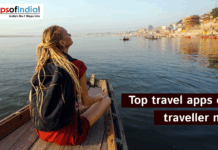 Top travel apps every traveller needs A solo traveler with a backpack sitting on a wooden boat, gazing across a calm river with boats and historic riverside buildings in the background, promoting top travel apps for travelers.