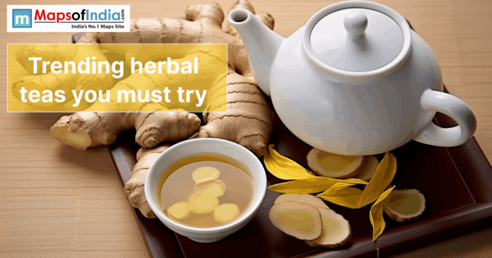 Trending herbal teas Banner image showing ginger roots, a cup of herbal tea, and a white teapot with the text “Trending herbal teas you must try” and Maps of India logo.