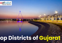 Top Districts of Gujarat Scenic waterfront view in Gujarat at sunset with illuminated walkway and modern architectural structure, showcasing urban development