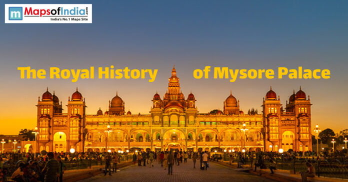 Illuminated Mysore Palace at dusk with visitors, showcasing its royal architecture and grandeur