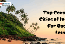 Top Coastal Cities of India For Beach Lovers Tropical beach with palm trees and rocky shore at sunset featuring text “Top Coastal Cities of India for Beach Lovers”