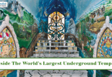 Inside The World’s Largest Underground Temple Colorful interior of a large underground temple featuring intricate murals, stained-glass artwork, and a grand central altar.