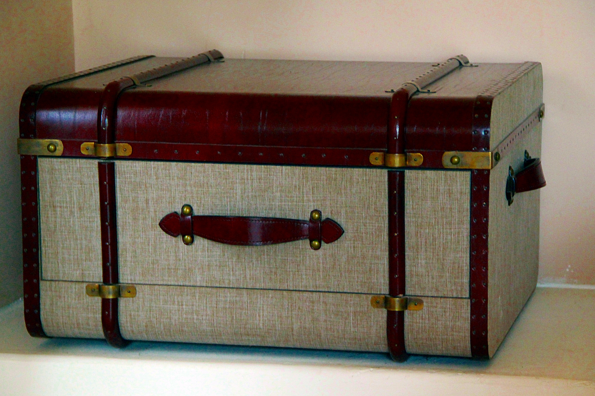 Leather strapped suitcase for bedside tables .
