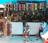 A man displays his merchandise at Dilli Haat, a bustling market in India, filled with colorful local products