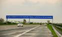 A highway sign for Yamuna expressway with a vehicle driving on the road